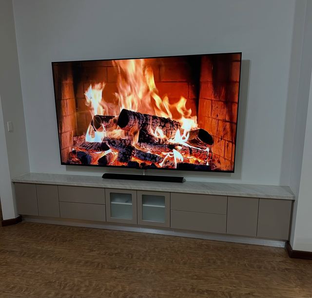 Low custom entertainment unit with a Le Taj stone benchtop beneath a wall-mounted television